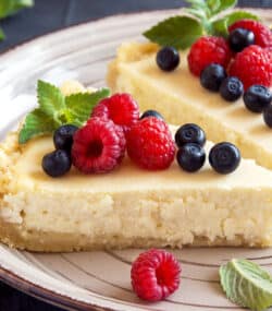Doua felii de cheesecake facut in casa, pe farfurie in bucatarie