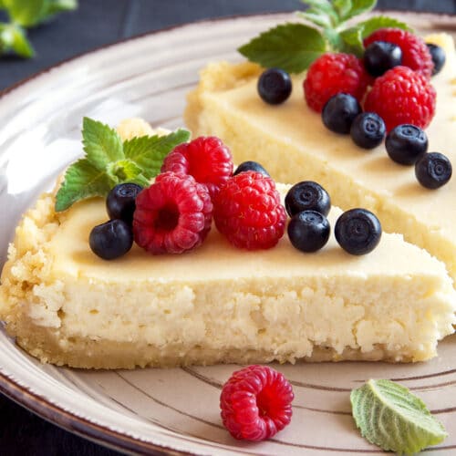 Doua felii de cheesecake facut in casa, pe farfurie in bucatarie
