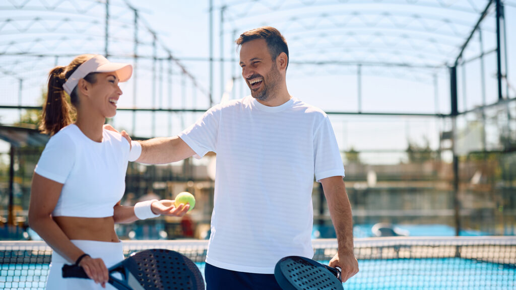 cuplu fericit pe teren de tenis zambesc dupa antrenament in aer liber