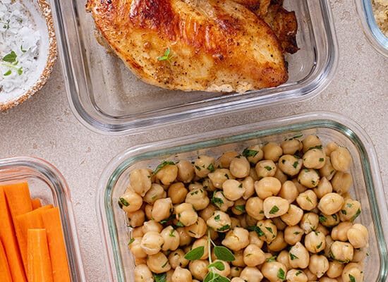 Varietate de alimente gatite, carbohidrati, proteine, legume in caserole pe masa in bucatarie