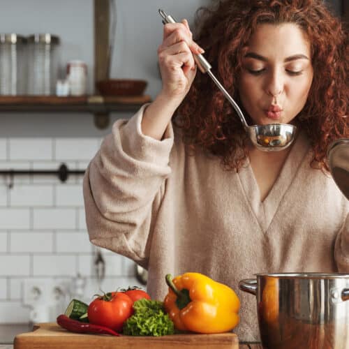 Femeie in bucatarie, pregateste supa de legume