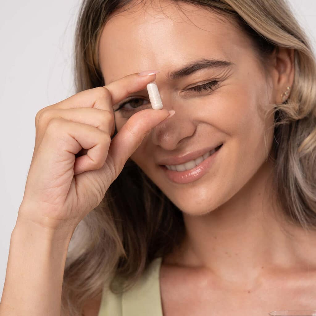 Femeie care ține în mâini o pastilă Kindora