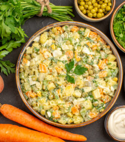 Imagine cu vedere de sus ce arată ingrediente sănătoase pentru salata boeuf: morcovi, țelină, prătunjel și altele