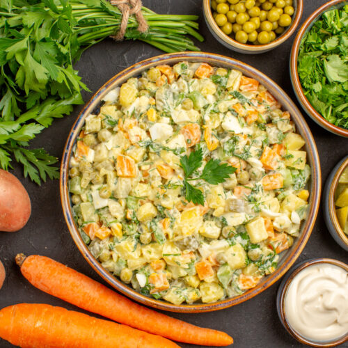 Imagine cu vedere de sus ce arată ingrediente sănătoase pentru salata boeuf: morcovi, țelină, prătunjel și altele