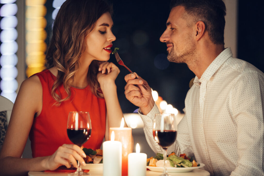 Imagine cu un cuplu la o cina romantică, la un pahar de vin rosu, considerat aliment afrodisiac