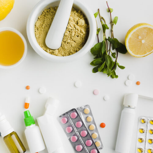 Imagine cu alimente utilizate drept antibiotice naturale, față în față cu pastile și antibiotice comune, pe un fundal alb