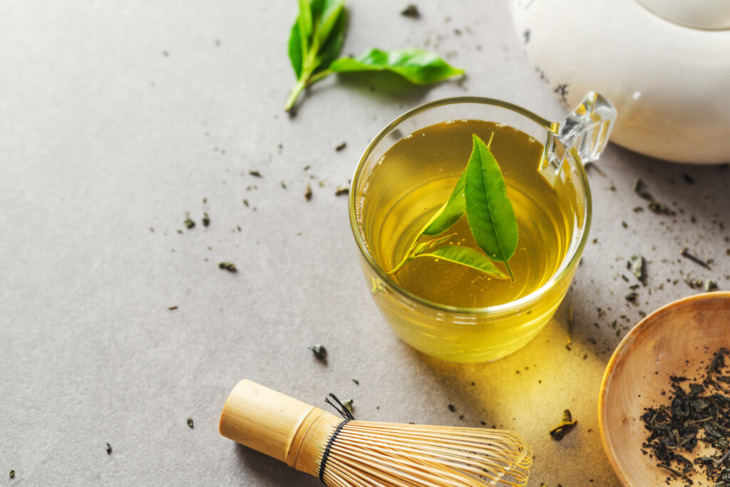 Imagine de sus cu o cană de ceai verde, pe un fundal gri