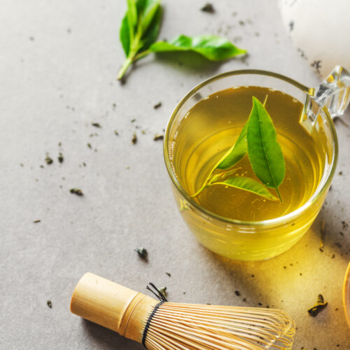 Imagine de sus cu o cană de ceai verde, pe un fundal gri