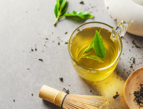 Imagine de sus cu o cană de ceai verde, pe un fundal gri