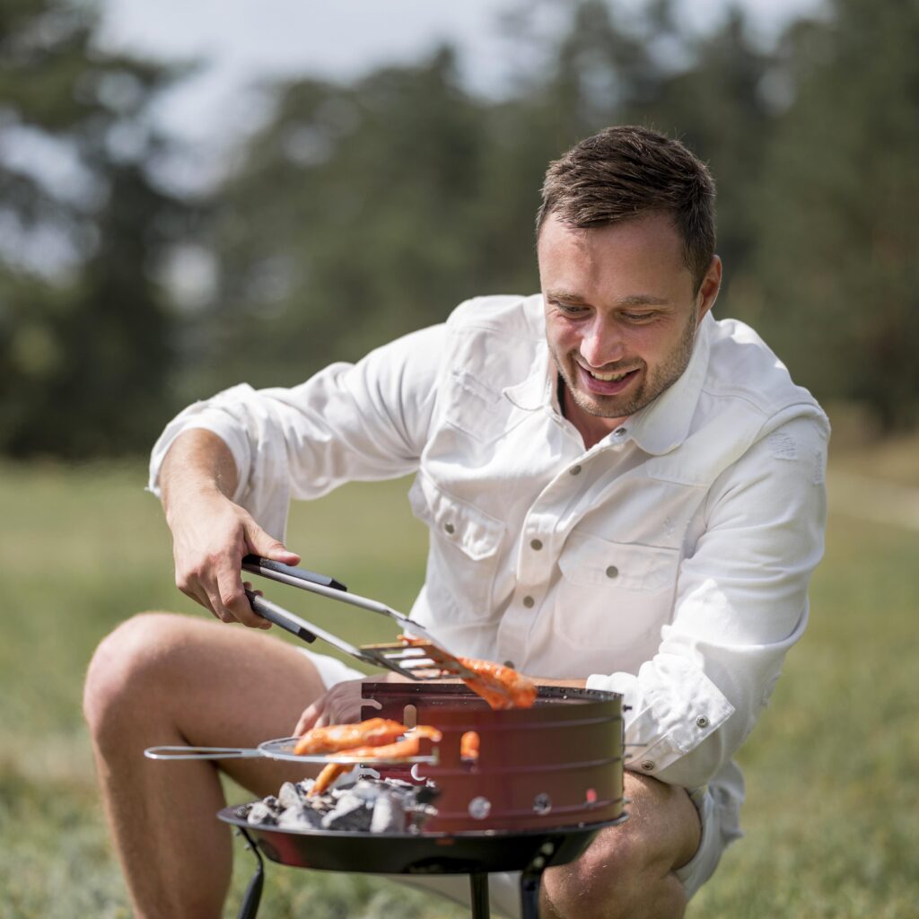 Bărbat tânăr care prepară carne la grătar în mod sănătos