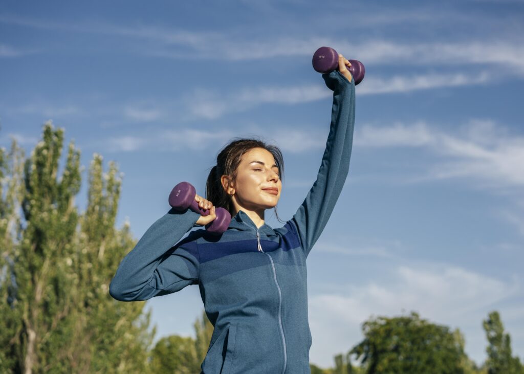 Imagine cu o femeie tanara care face exercitii sport afara in natura