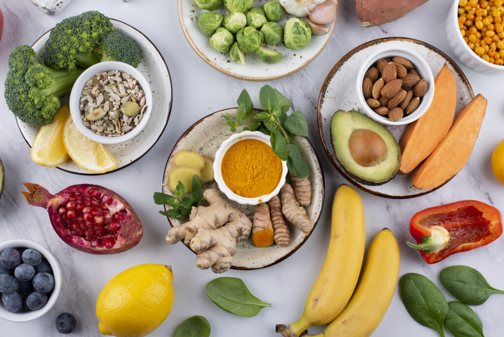 Imagine de sus cu o varietate de alimente sănătoase, benefice pentru microbiomul intestinal: legume, fructe, rădăcinoase