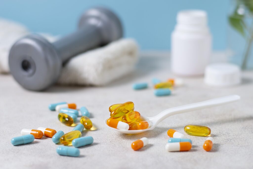 Imagine de aproape cu diferite pastile de suplimente si medicamente rasfirate pe o masa alba