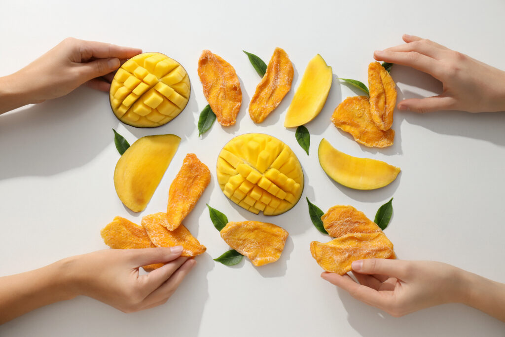 Bucati de mango proaspat si uscat, pe un fundal alb