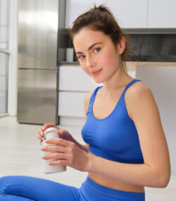 tanara imbracata sport in bucatarie consuma suplimente