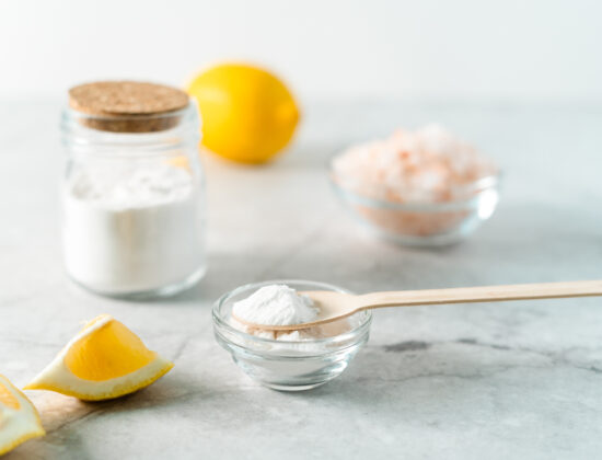 borcănel de bicarbonat de sodiu langă jumătăți de lămâie și un castronel cu sare in spate