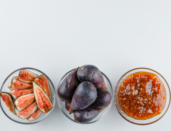 Imagine de sus, pe fundal alb: 3 borcanele transparente, unul cu smochine taiate, unul cu smochine intregi si unul cu dulceata de smochine