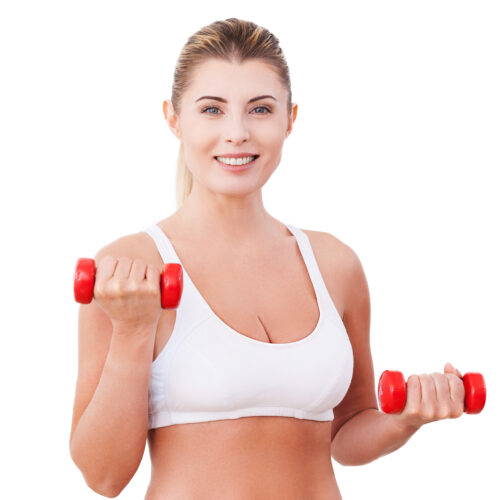 Mature woman with dumbbells. Attractive mature woman in sports clothing training with dumbbells and smiling while standing isolated on white