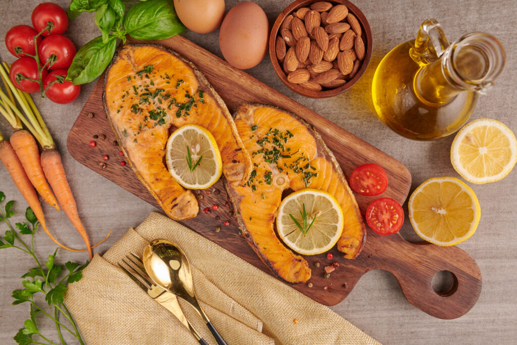 Imagine cu vedere de sus cu surse naturale de omega 3, alimente proaspete cu grasimi sanatoase: somon, oua, ulei de pește, migdale