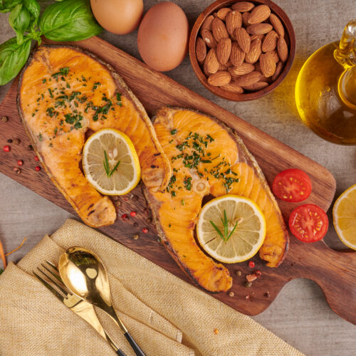 Imagine cu vedere de sus cu surse naturale de omega 3, alimente proaspete cu grasimi sanatoase: somon, oua, ulei de pește, migdale