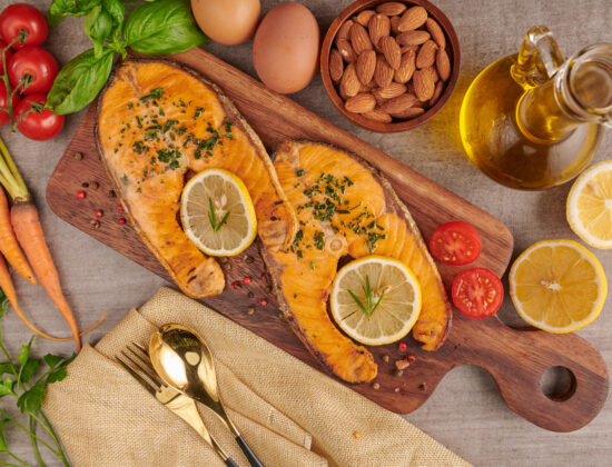 Imagine cu vedere de sus cu surse naturale de omega 3, alimente proaspete cu grasimi sanatoase: somon, oua, ulei de pește, migdale