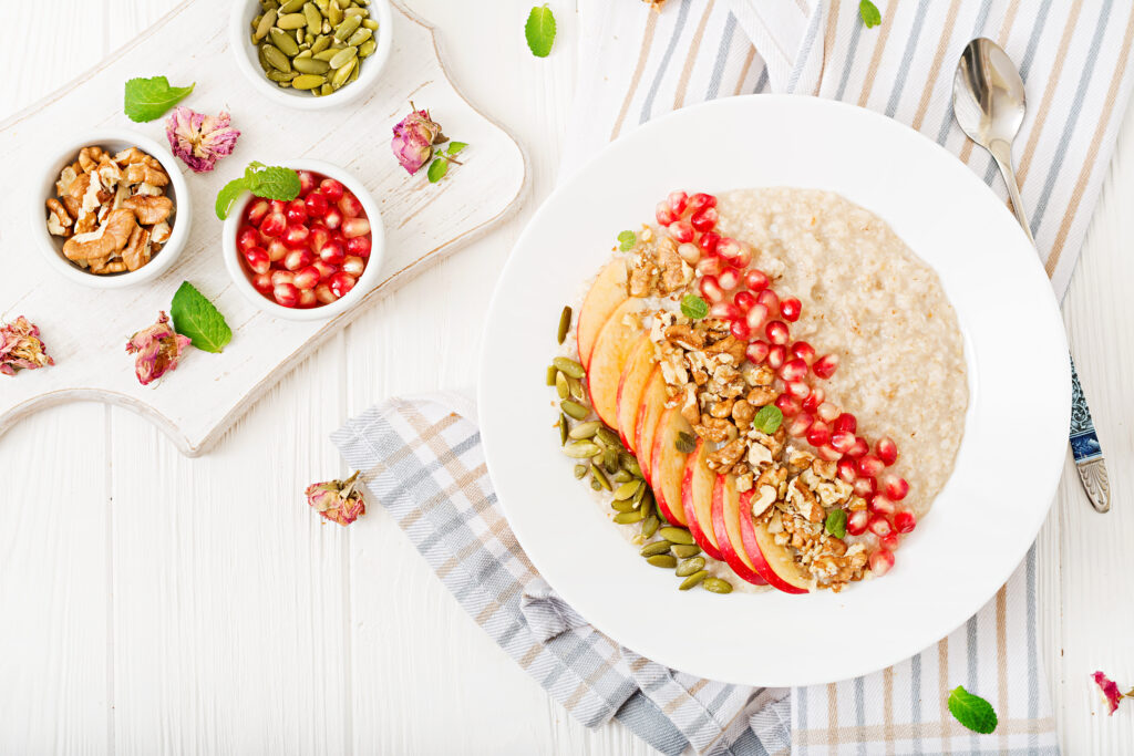 Imagine de sus cu un preparat sănătos cu ovăz integral, rodie, nuci si seminte, potrivit pentru a implini carentele nutritive din dieta balerina
