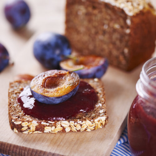 gem de prune pe paine din cereale integrale, jumatati de prune in jur