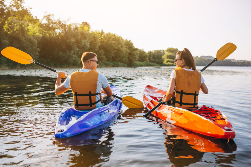 Cuplu care practică canoe, sport nautic de vara care ajuta la arderea rapida a caloriilor