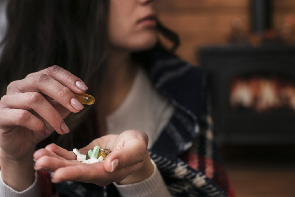 Imagine de aproape, femeie ține diferite suplimente în palmă, necesare în dietă