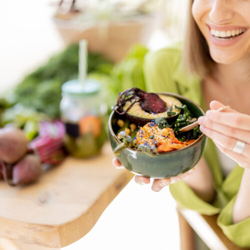 Femeie tânără și fericită mănâncă un preparat sănătos din dieta fix la fix, imagine de aproape