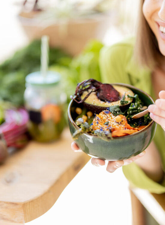 Femeie tânără și fericită mănâncă un preparat sănătos din dieta fix la fix, imagine de aproape