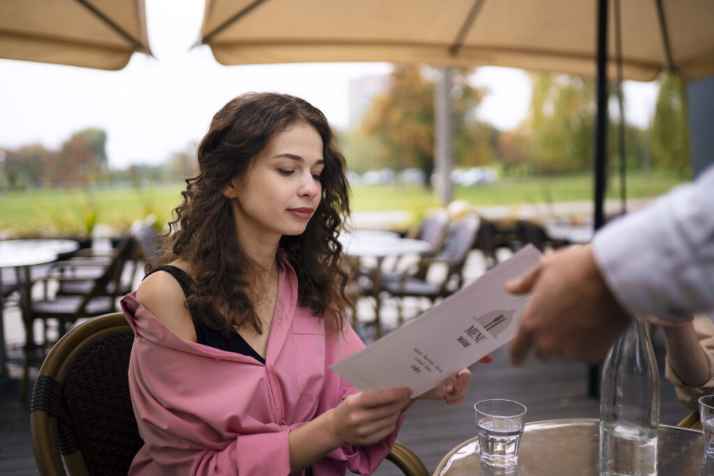 Fată tânără la restaurant, alege alimente optime pentru dieta Ornish din meniu