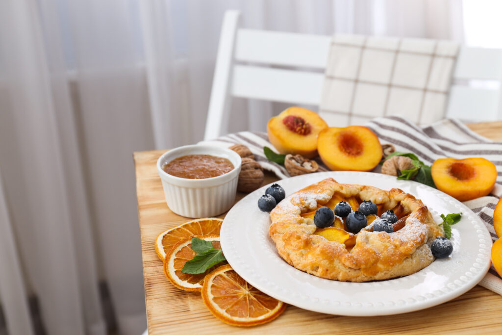 mic dejun pe masa, tarta dulce cu afine si piersici si gem 