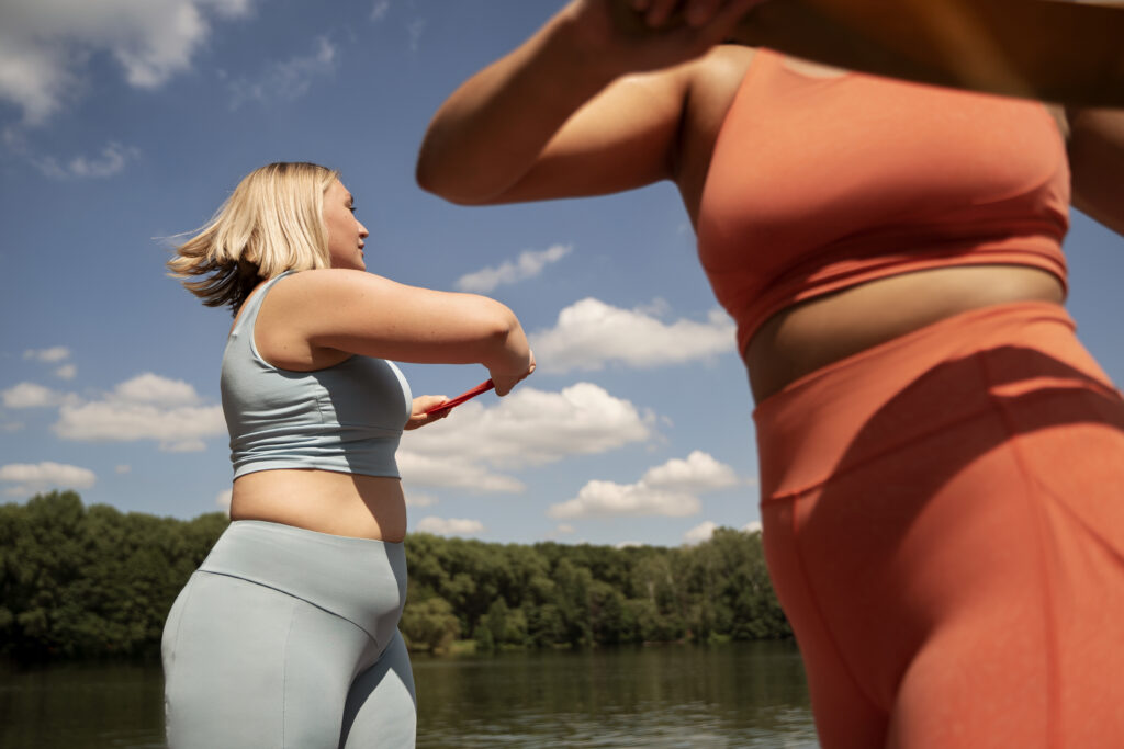 Imagine de aproape, femei care fac exerciții sport în aer libere. Amândouă sunt îmbrăcate în echipamente sport