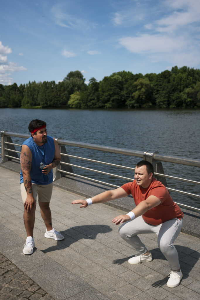 2 bărbați fac antrenamente sport pe un ponton, pentru a-și îmbunătăți mișcarea zilnică