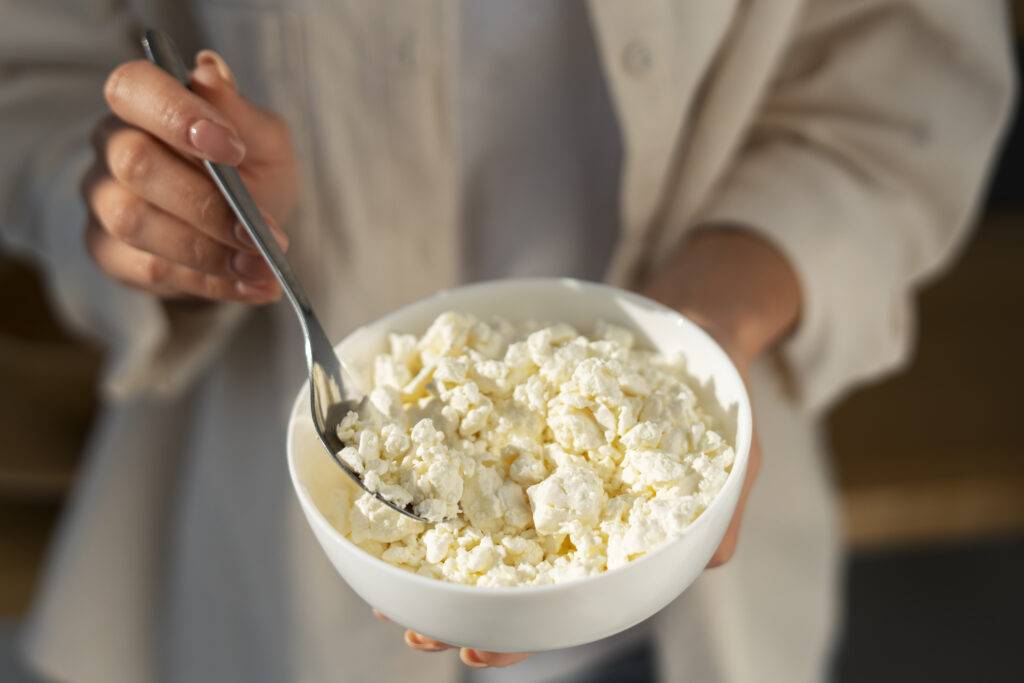 Persoană ține un bol de cottage cheese în mâini
