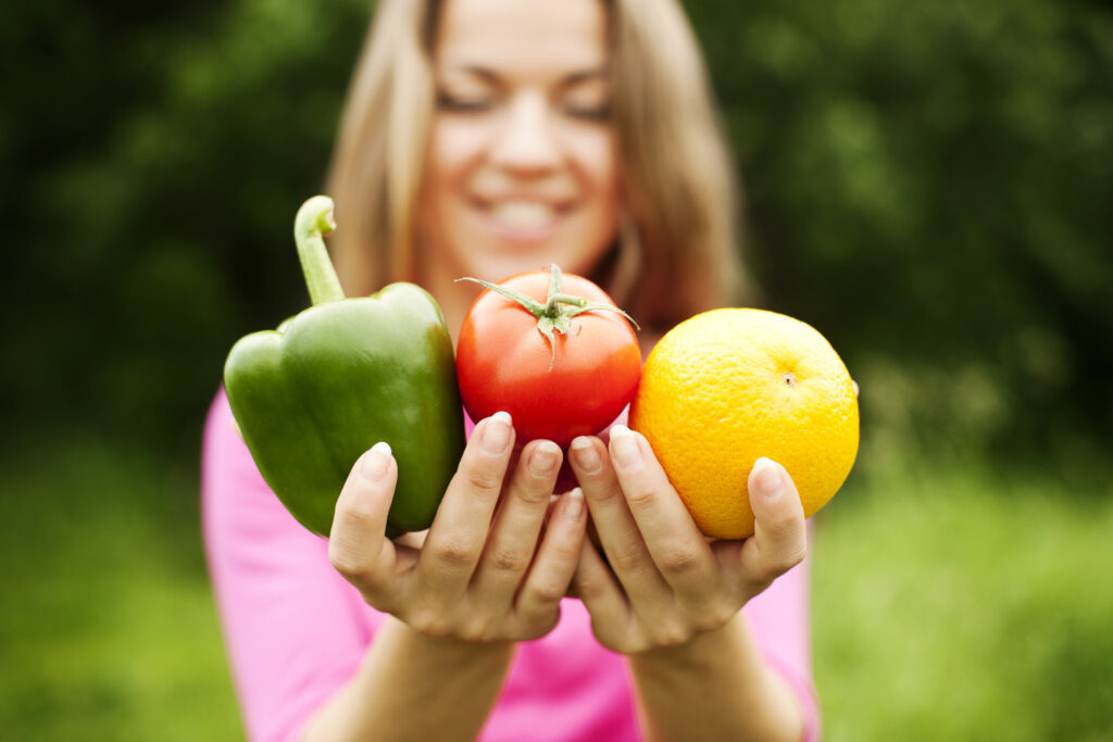 Femeie tânără, ține fructe și legume în mâini, alimente proaspete, integrale