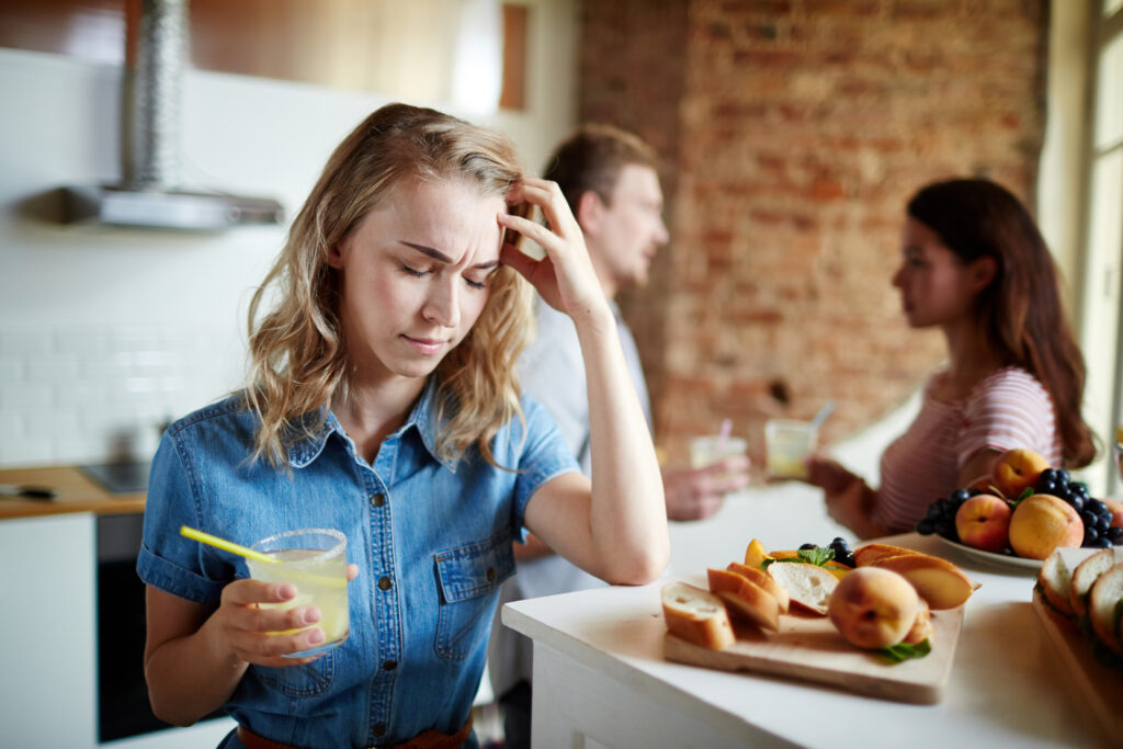Fată cu dureri de cap la o petrecere. Posibil efect secundar în dieta de 800 calorii
