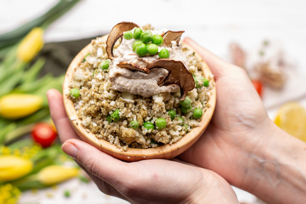 Imagine de aproape, persoană care ține în mâini un bol de quinoa, aliment permise în dieta Sirtfood