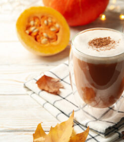 2 căni cu pumpkin spice latte rețetă de dietă, cu jumătătți de dovleac în fundal