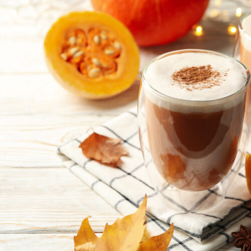 2 căni cu pumpkin spice latte rețetă de dietă, cu jumătătți de dovleac în fundal