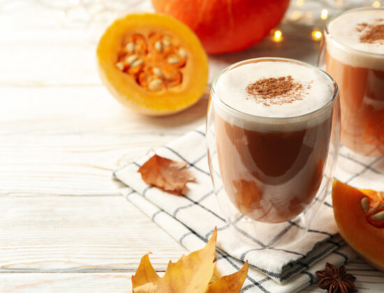 2 căni cu pumpkin spice latte rețetă de dietă, cu jumătătți de dovleac în fundal