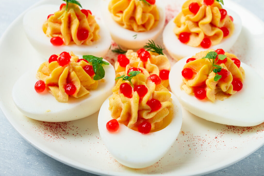 Imagine de aproape, felii de ouă umplute decorate cu pătrunjel și caviar