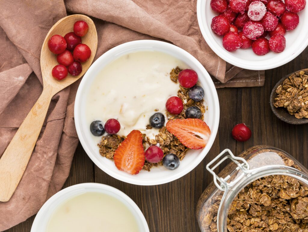 Imagine de sus, preparat cu iaurt, cereale integrale și fructe de pădure, toate alimente permise în dieta nordică