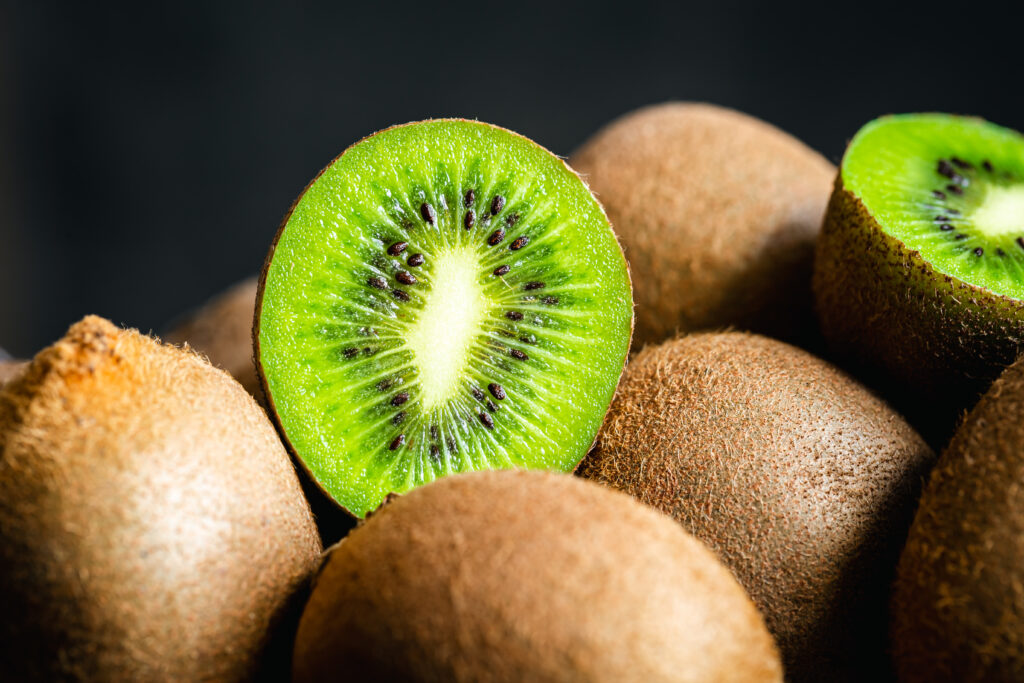 mai multe fructe kiwi, unul este taiat pe jumatate